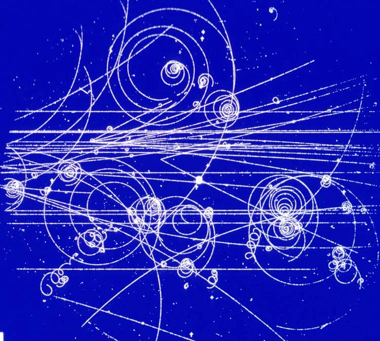 Particle tracks spiralling across a dark blue cloud chamber photograph